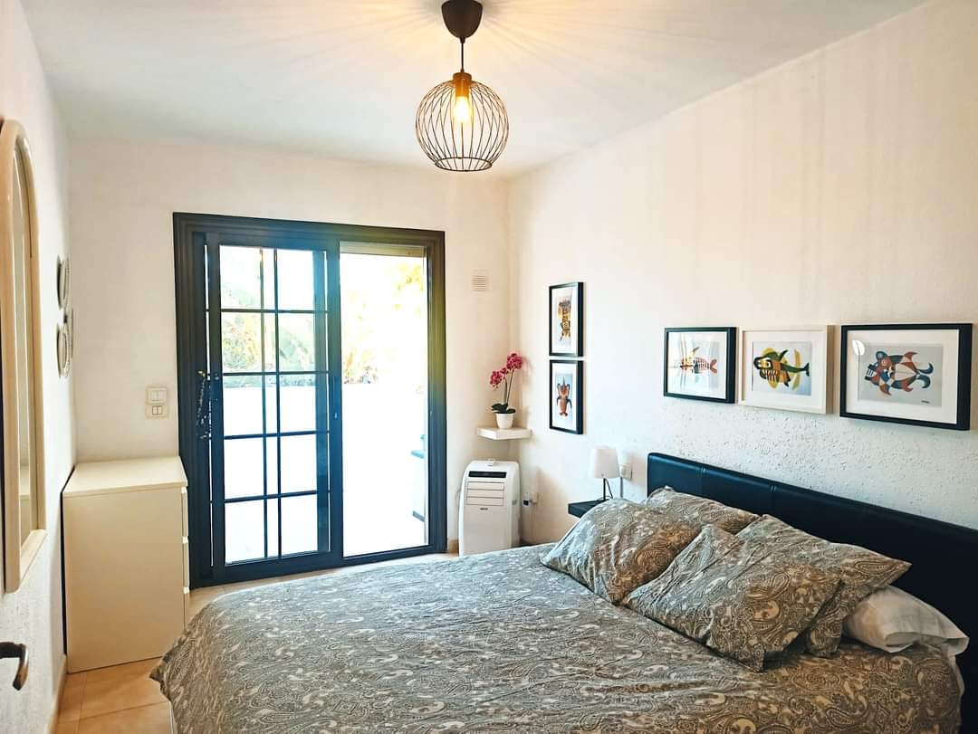 San Miguel de Abona Cozy House at Amarilla Golf spacious bedroom with queen-size bed and large windows
